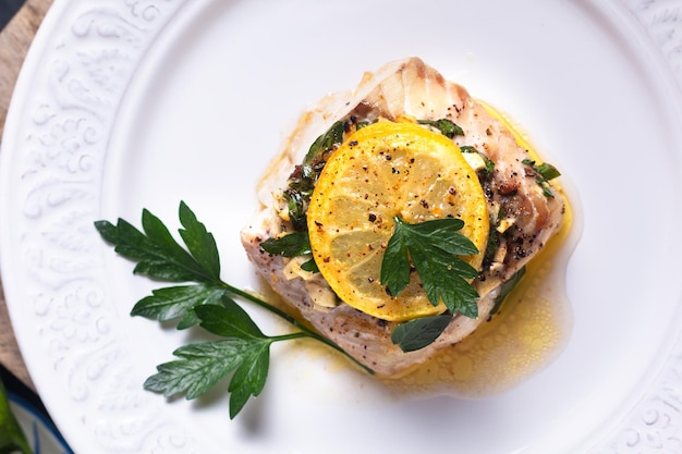 健康食品のコンセプト自家製レモンガーリックバターコピースペースと黒の背景に焼きタラの魚