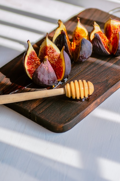 Healthy food concept. Light background. Ripe figs on a dark wooden board.