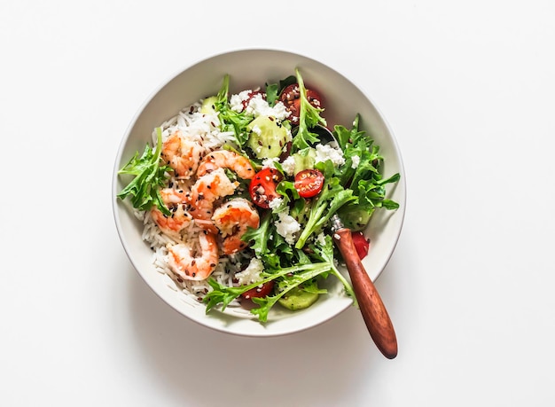 Концепция здорового питания обед рисовые креветки и салат из свежих овощей в одной миске на светлом фоне вид сверху