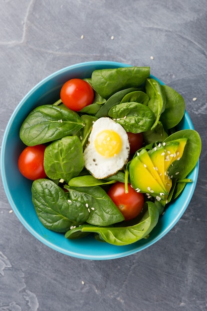 Healthy food concept. Salad in blue bowl on dark background. 