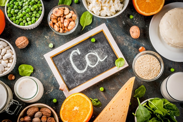 Foto concetto di cibo sano. set di alimenti ricchi di calcio - latticini e prodotti vegani ca sfondo blu scuro