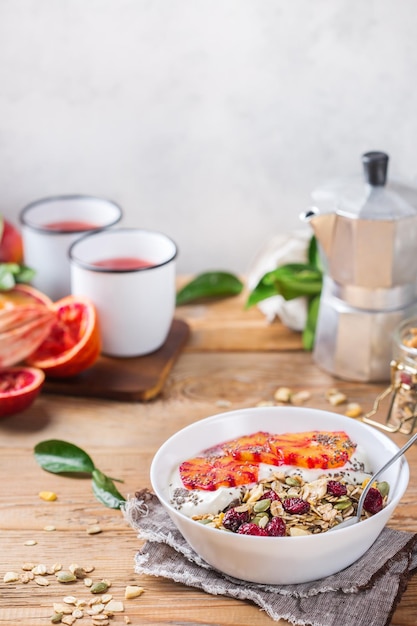 Healthy food diet and nutrition concept Early morning breakfast with homemade granola muesli natural yogurt seasonal ripe blood oranges