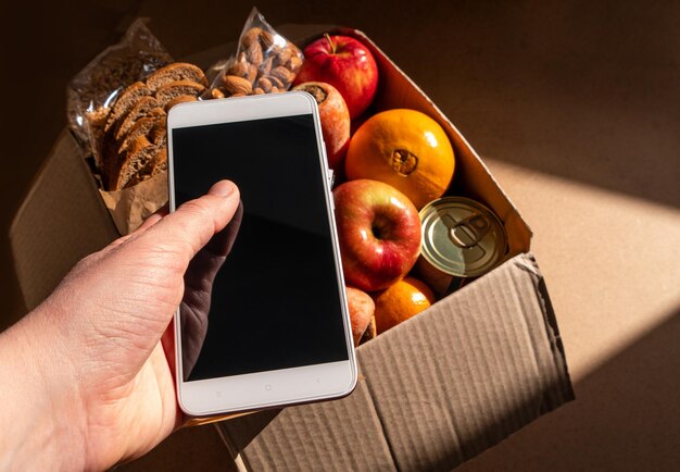 Foto cibo sano consegna rapida smartphone touchscreen mockup banner con ombre dure portare via il pacchetto di prodotti del supermercato