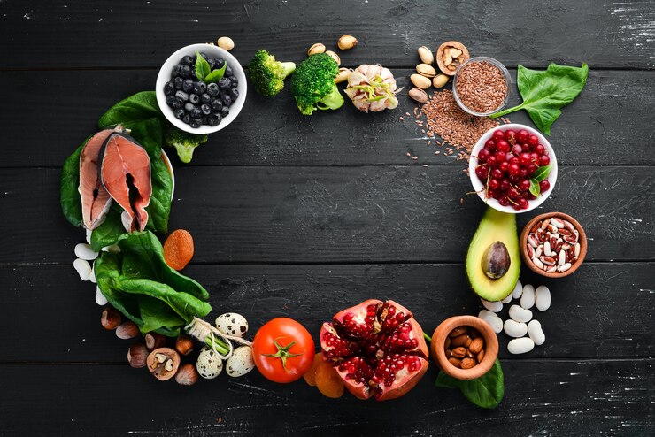 Healthy food Fish blueberries nuts pomegranate avocados tomatoes spinach flax Concept of Dietary Nutrition Top view