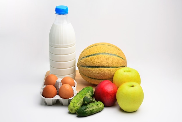 Healthy food fish vegetables fruits milk and eggs on white\
background