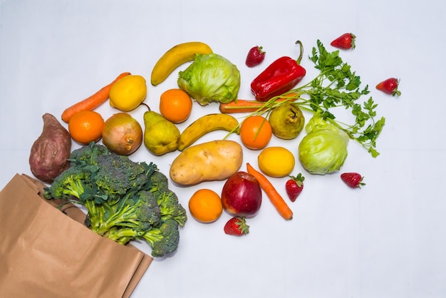 Healthy food fruits and vegetables in a shopping bag vegetarian white background