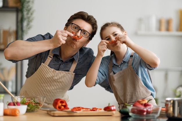 Photo healthy food at home. happy family in the kitchen. father and child daughter are preparing proper meal.