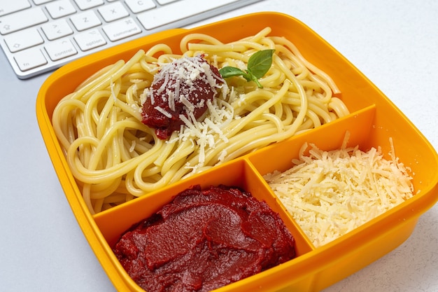 작업 테이블에 토마토, 치즈, 바질과 함께 만든 스파게티와 함께 먹을 준비가 플라스틱 용기에 건강 식품. 이탈리아 음식. 빼앗아.