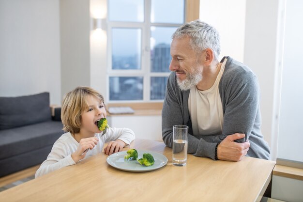 Healthy food. Mature man and his son having breakfast together