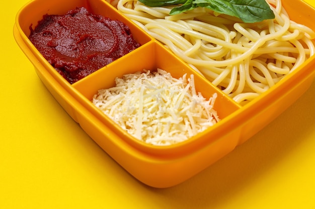 Healthy Food in Plastic containers ready to eat with homemade spaghetti with tomato, cheese and basil on the work table. Italian food. To take away.