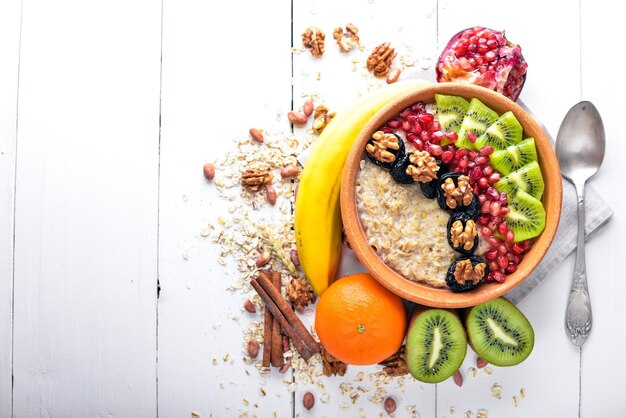 Healthy food porridge with fruit kiwi banana and nuts On Wooden background Top view