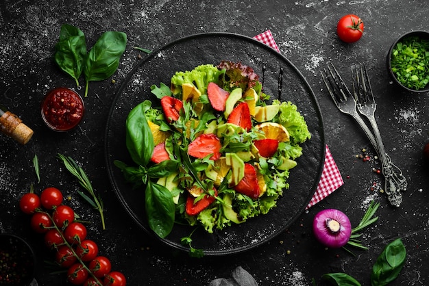 Healthy food salad of arugula avocado strawberry and orange Top view Free space for your text