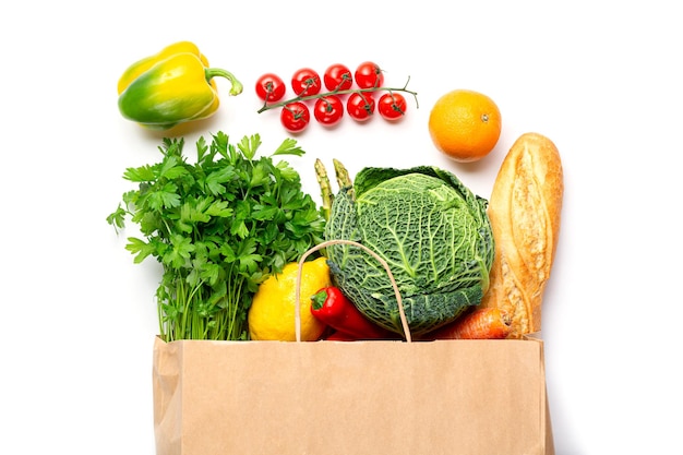 Healthy food in shopping bag. Vegetables, fruits assortment and bottle of milk isolated on white background. Vegetarian healthy food concept.