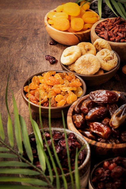 Healthy food snack sun dried organic mix of dried fruits apricots figs raisins dates and other on wooden table top view