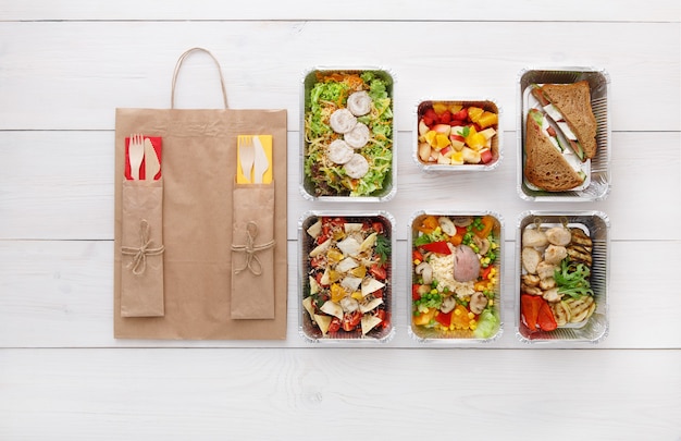 Healthy food take away in boxes top view on wooden table