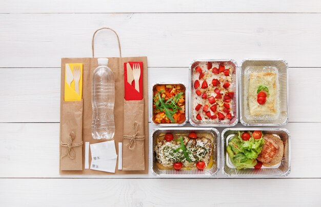 Healthy food take away in boxes top view on wooden table