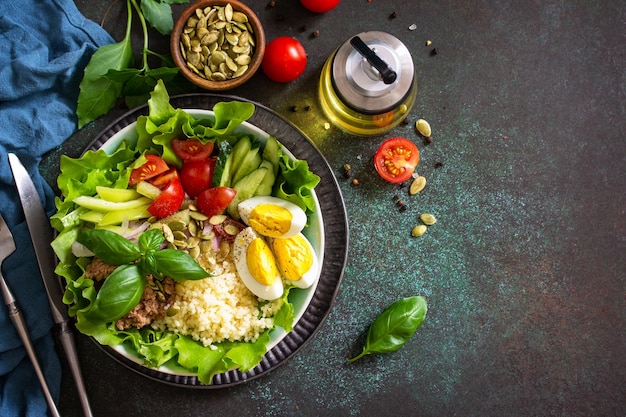 Healthy food Tuna salad with egg lettuce quinoa vegetables and pumpkin seeds Top view