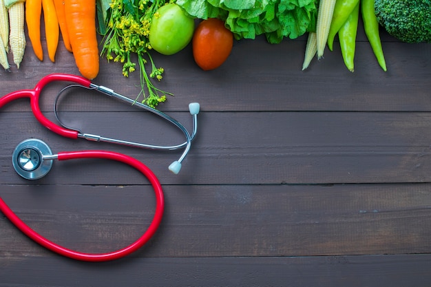 Healthy food, vegetables organic on wooden background with glass of milk and stethoscopes