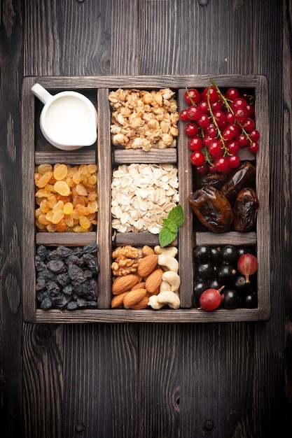 Healthy food in wooden box Granola berries nuts dried fruit and milk