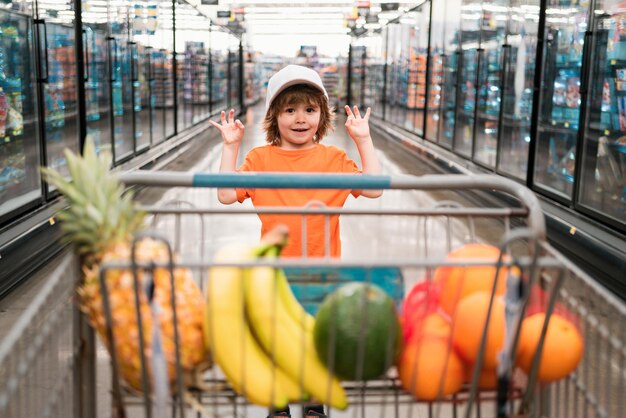 Photo healthy food for young family with kids boy at grocery store or supermarket portrait of funny little