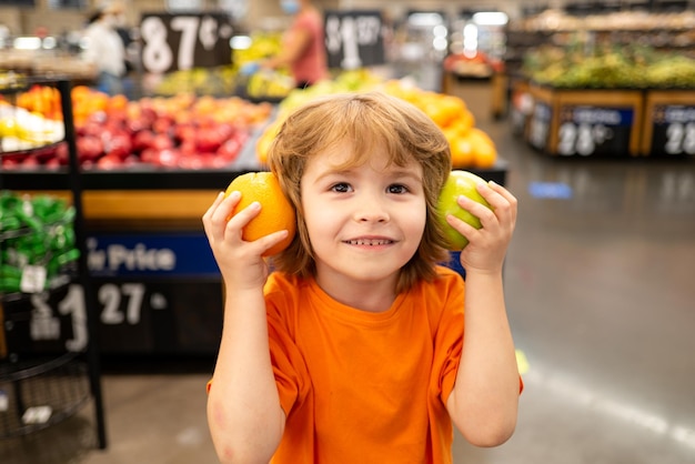 子供と若い家族のための健康食品でいっぱいの買い物袋を持っている面白い小さな子供の肖像画