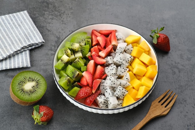 Healthy fresh fruit salad bowl dragon fruit kiwi mango strawberry on the table Selected focus