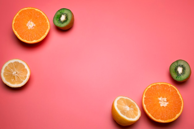 분홍색 배경에 있는 건강한 신선한 과일 오렌지 레몬 키위 텍스트를 위한 여유 공간