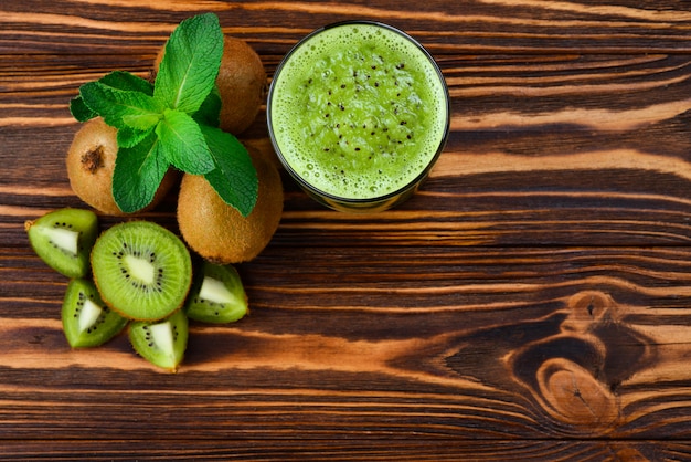 Healthy fresh kiwi smoothie in glass on a wooden table