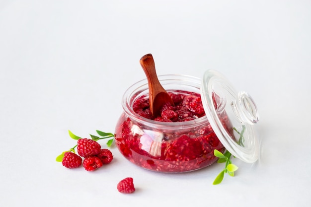 Healthy fresh raspberries, homemade jam in a jar