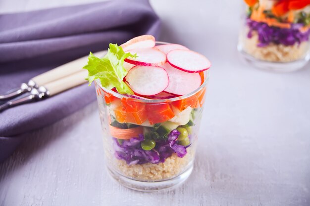 Healthy fresh salad in glassful with vegetables on the wooden table