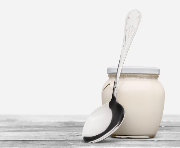 Healthy fresh  yogurt with spoon on background