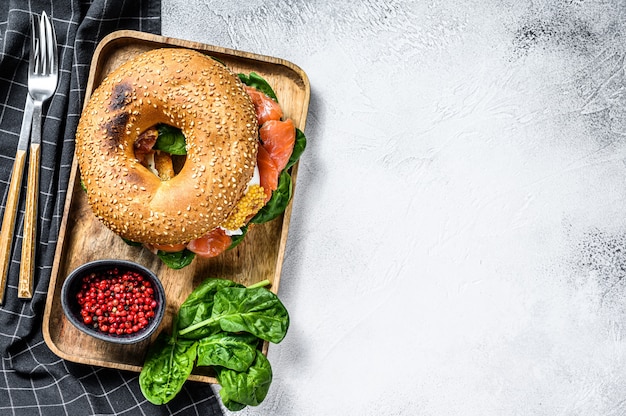 Bagel appena sfornato sano riempito con salmone affumicato, spinaci e uovo.