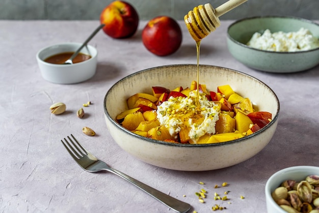 Healthy fruit salad with nectarine ricotta cream with pistachios and honey