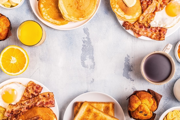healthy full american breakfast with eggs bacon pancakes and latkes, top view.