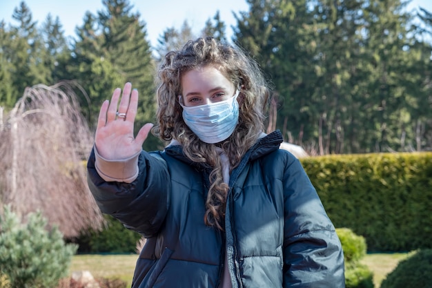 사진 제스처 중지를 표시하는 의료 보호 마스크에 건강 한 여자.