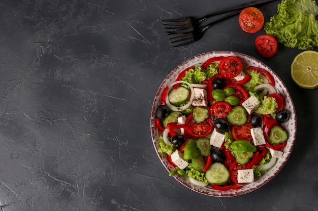Полезный греческий салат из зеленого салата, помидоров черри, сыра фета, черных оливок и огурцов