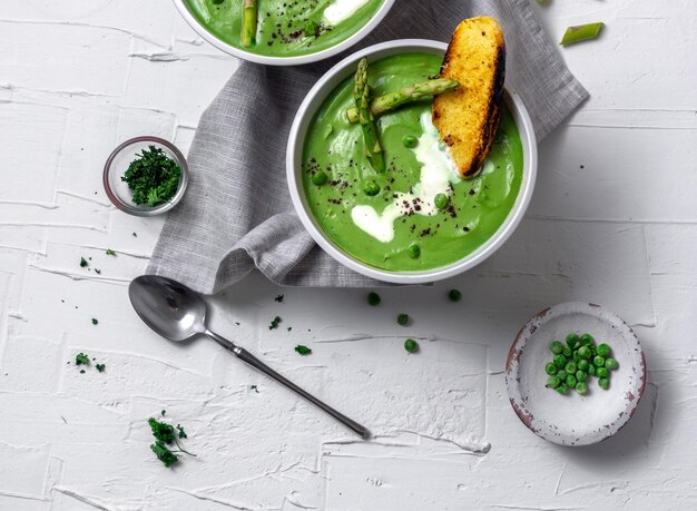 Healthy Green Asparagus Soup with Peas in white background Dietary food Healthy food Detox Food Top view