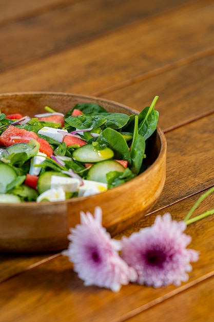 Healthy green mix salad in bowl with spinach tomato oil and cucumber