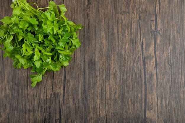 Healthy green parsley leaves placed on wooden surface