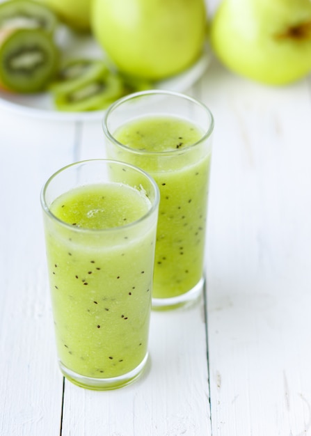 Healthy green Smoothie apple and kiwi on white table