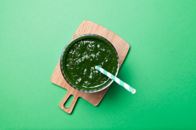 Healthy green smoothie on a green table. Top view