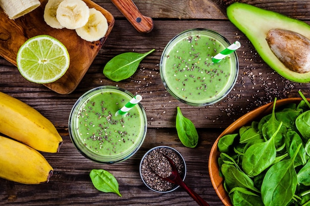 Photo healthy green smoothie with banana lime spinach avocado and chia seeds in glass jars on a rustic background