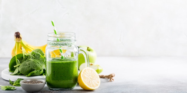 Healthy green smoothie with spinach in glass jar