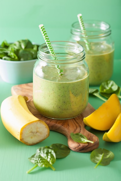 Healthy green smoothie with spinach mango banana in glass jars