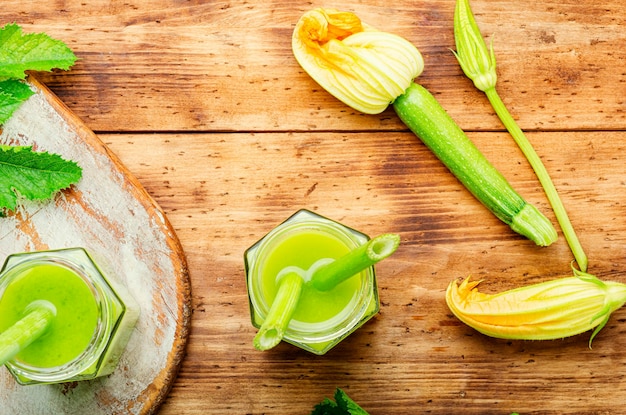 Healthy green smoothie with zucchini in glass jars on a rustic wooden background