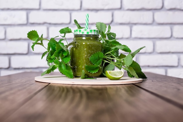 Healthy green spinach smoothie in jar on wooden table selective focus