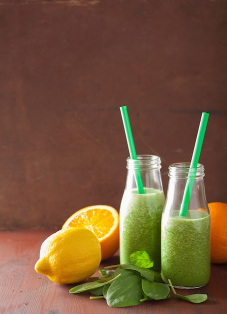 Healthy green spinach smoothie with lemon and orange