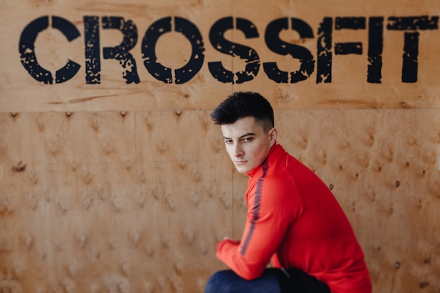 Ragazzo sano sullo sfondo dell'iscrizione crossfit