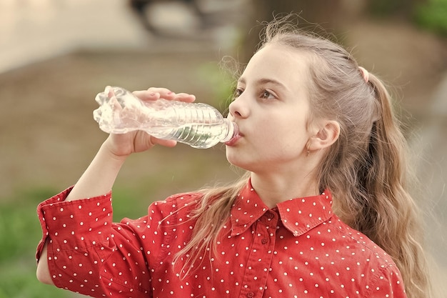 Healthy habits healthy and hydrated girl care about health and\
water balance girl cute kid hold water bottle water balance concept\
drink water while walk teach kids about body hydration