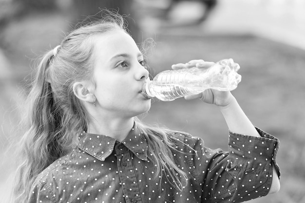 Healthy habits Healthy and hydrated Girl care about health and water balance Girl cute kid hold water bottle Water balance concept Drink water while walk Teach kids about body hydration